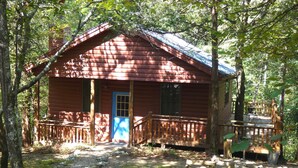 A rustic cabin with a wooden deck and a blue door. - "The Sugar Shack" Cabin 2 (Oden)