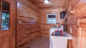 Une petite salle de bain en bois, avec un lavabo, un miroir et une fenêtre.