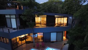 A modern two-story house with a swimming pool, large windows, and a balcony. - Modern Beach Home with Pool & Rooftop - 150 metros (Santa Cruz, Playa Avellanas)
