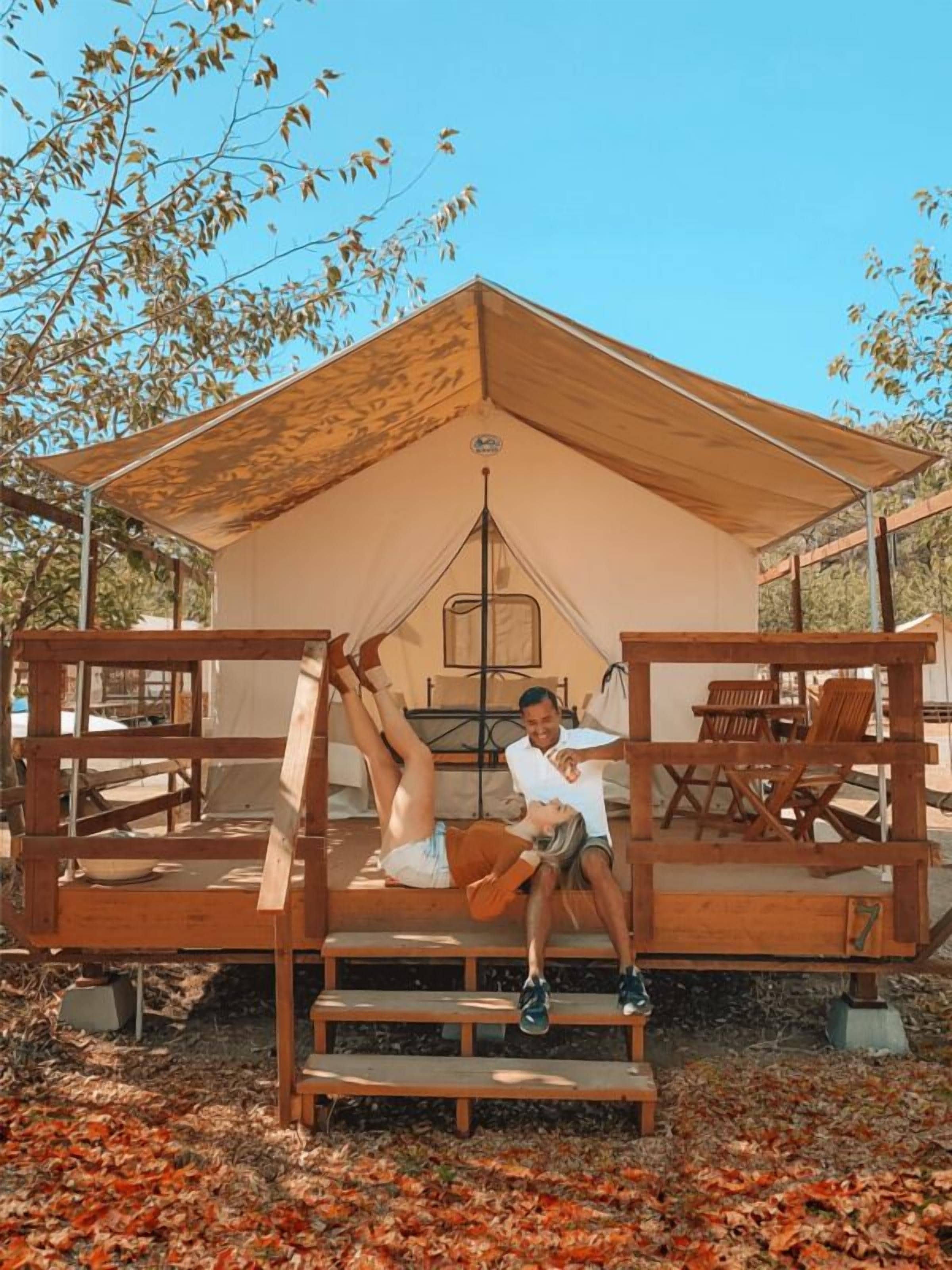 A wooden deck with a tent structure in the background.