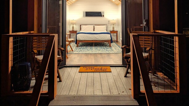 A cozy cabin with a loft bedroom, wooden exterior, and a small balcony. - Wildhaven Sonoma Glamping (Healdsburg)