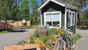 A small building with a sign reading "WELCOME to Wildhaven STOP at the Kiosk" and a bicycle parked in front. - Wildhaven Sonoma Glamping (Healdsburg)