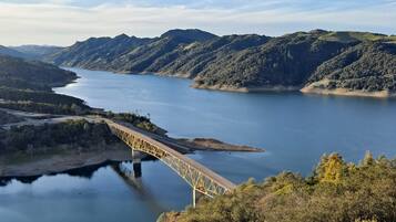 Un puente sobre un río tranquilo, con colinas circundantes y cielo despejado.
