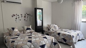 A bedroom with two beds, an air conditioning unit, a wardrobe, and a hanging light fixture. - VISTA AL MAR (Santa Marta)