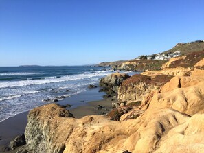 A coastal landscape with rocky cliffs and a beach.