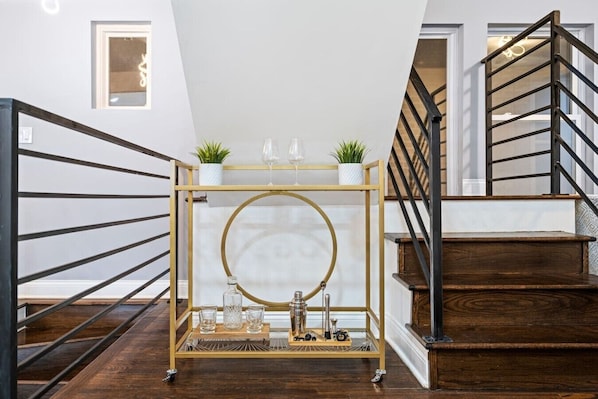 Una escalera con acabado de madera y barandilla de metal, que conduce a un piso superior.