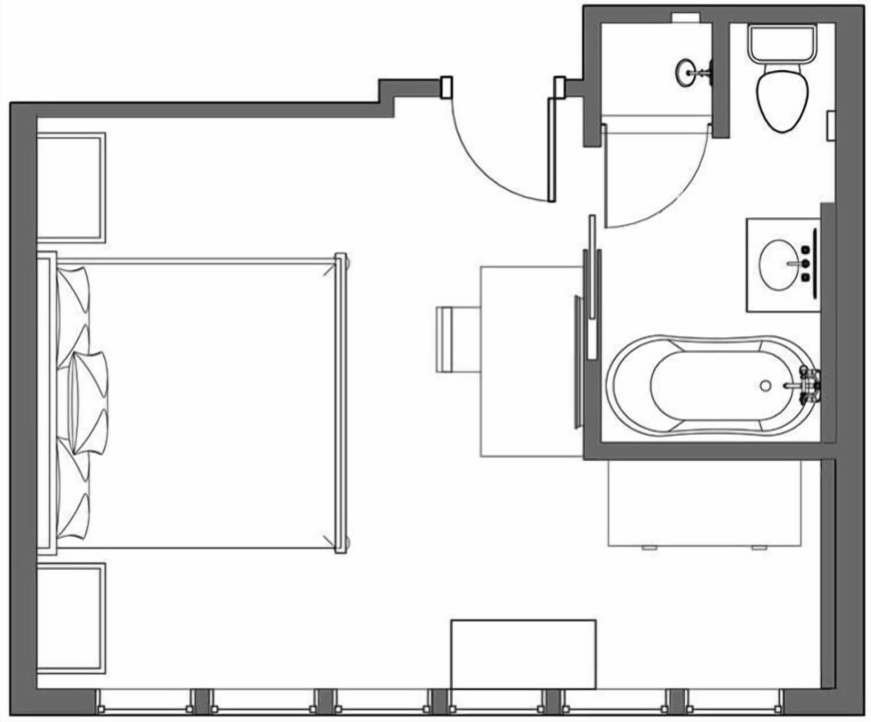 Distribución de una habitación de hotel con cama, baño que incluye una bañera y una pequeña zona de estar.