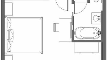 Distribución de una habitación de hotel con cama, baño que incluye una bañera y una pequeña zona de estar.
