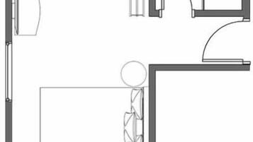 Indeling van een hotelkamer met een bed, zithoek, badkamer en een klein kitchenette.