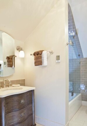 Bathroom features a large mirror, vanity with cabinet and countertop, and a glass shower enclosure.