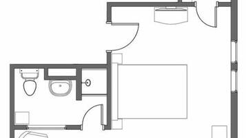 Un plan d’étage d’une chambre d’hôtel comprenant une salle de bain, un lit, un bureau et une chaise.