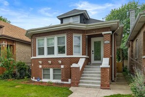 Stunning two-story home with a charming front entrance and beautifully manicured lawn.