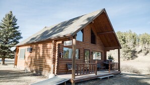 A log cabin with a porch, a ramp, and a sign that reads "Bluebird."