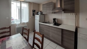 Una cocina moderna con microondas integrado, cafetera y lavavajillas Bosch.
