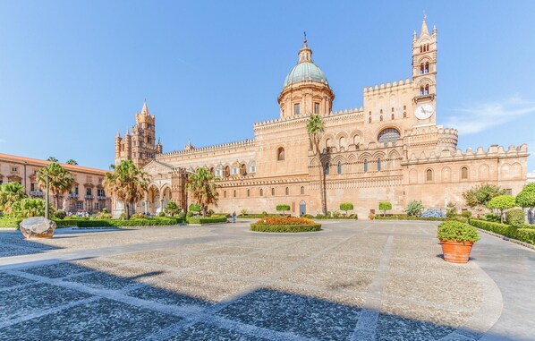 Un gran edificio histórico con una cúpula destacada y un torre con reloj.