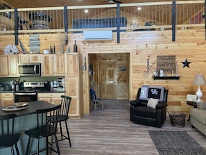 A cozy cabin interior with a kitchen, dining area, and living room.