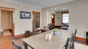 A dining area with a wooden table, chairs, and a world map artwork on the wall. - Cheerful 4-Bedroom home in Midtown Omaha (Omaha)