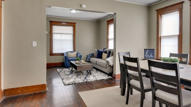 A living room with a sofa, coffee table, and dining area with chairs and a table. - Cheerful 4-Bedroom home in Midtown Omaha (Omaha)