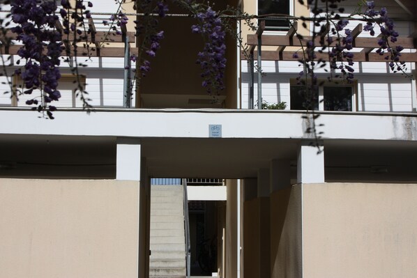 A building with a balcony and a sign indicating a local velos bike rental service.