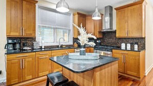 Una cocina moderna con armarios de madera, una isla central y una encimera negra.