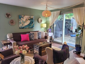 A living room with a sofa, coffee table, and a vase of flowers.