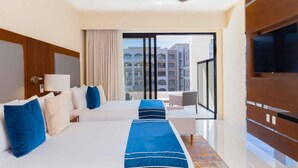 A hotel room with two beds, a TV, a balcony with a view of buildings, and a modern design. - Spacious Two Bedroom Suite....Amazing Pools including a Lazy River (San José del Cabo)