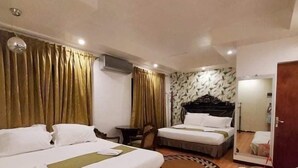 Une chambre d’hôtel avec deux lits, un bureau, une chaise et un miroir.