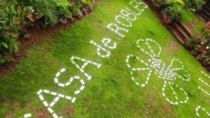 Un chemin de jardin orné d’un motif blanc formant les lettres « ASA de ROLES » et d’un motif floral.