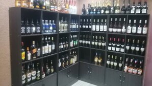 Una licorería con estantes llenos de diferentes botellas de alcohol.