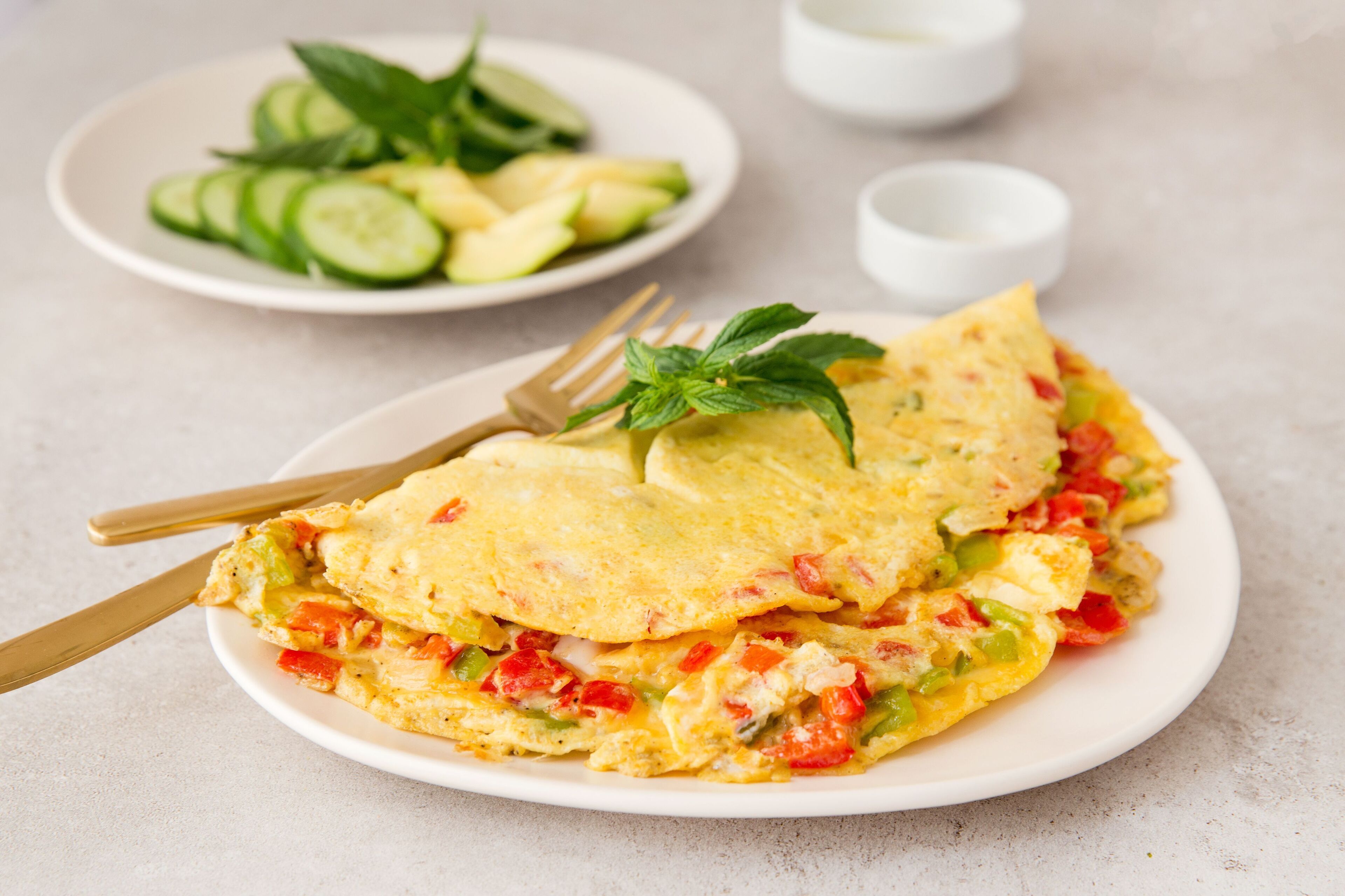 Un plato de tortilla con verduras y una ensalada.
