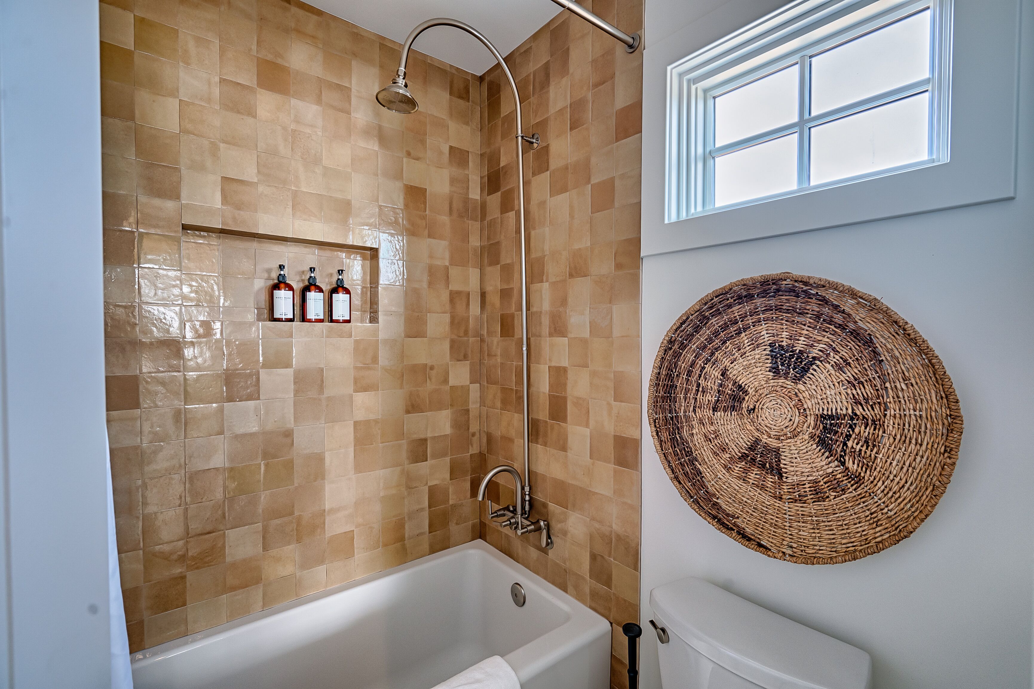 A bathroom with a bathtub, a shower, and a window.