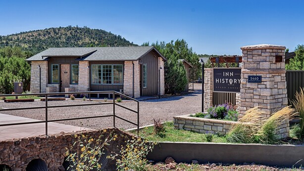 A stone building with a sign reading "Inn History" and "Grand Canyon."