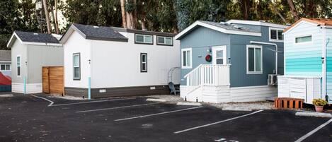A row of mobile homes with a parking lot in front.