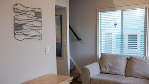 A living room with a beige sofa, a wooden table, and a wall art piece.