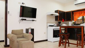 Una cucina compatta con TV, zona pranzo e divano.