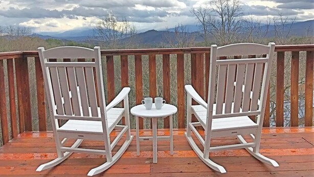 Two rocking chairs and a small table on a wooden deck with a view of mountains and trees. - Mountainside cabin with breathtaking views/hot tub/arcade/pet friendly (Pigeon Forge)