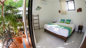 A bedroom with a bed, a ceiling fan, a window with curtains, a potted plant, and a wooden ladder.