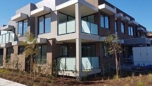 A modern multi-story residential building with large windows and a flat roof. - StayCentral-Heidelberg Heights Penthouse (Heidelberg Heights)