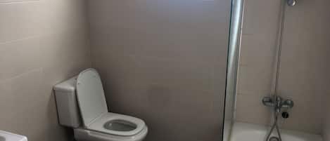 A bathroom with a toilet, bidet, and bathtub.