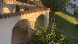 Blick auf ein Wohngebiet mit Häusern, einer Palme und einer Steinbrücke.