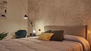 Une chambre à coucher comprenant un lit, un bureau, une chaise et un mur orné d’un motif en bambou.