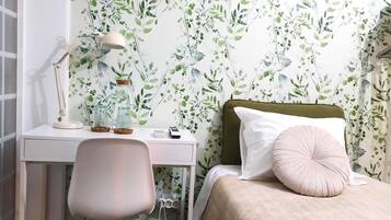 Een slaapkamer met een bed, een bureau en een stoel.