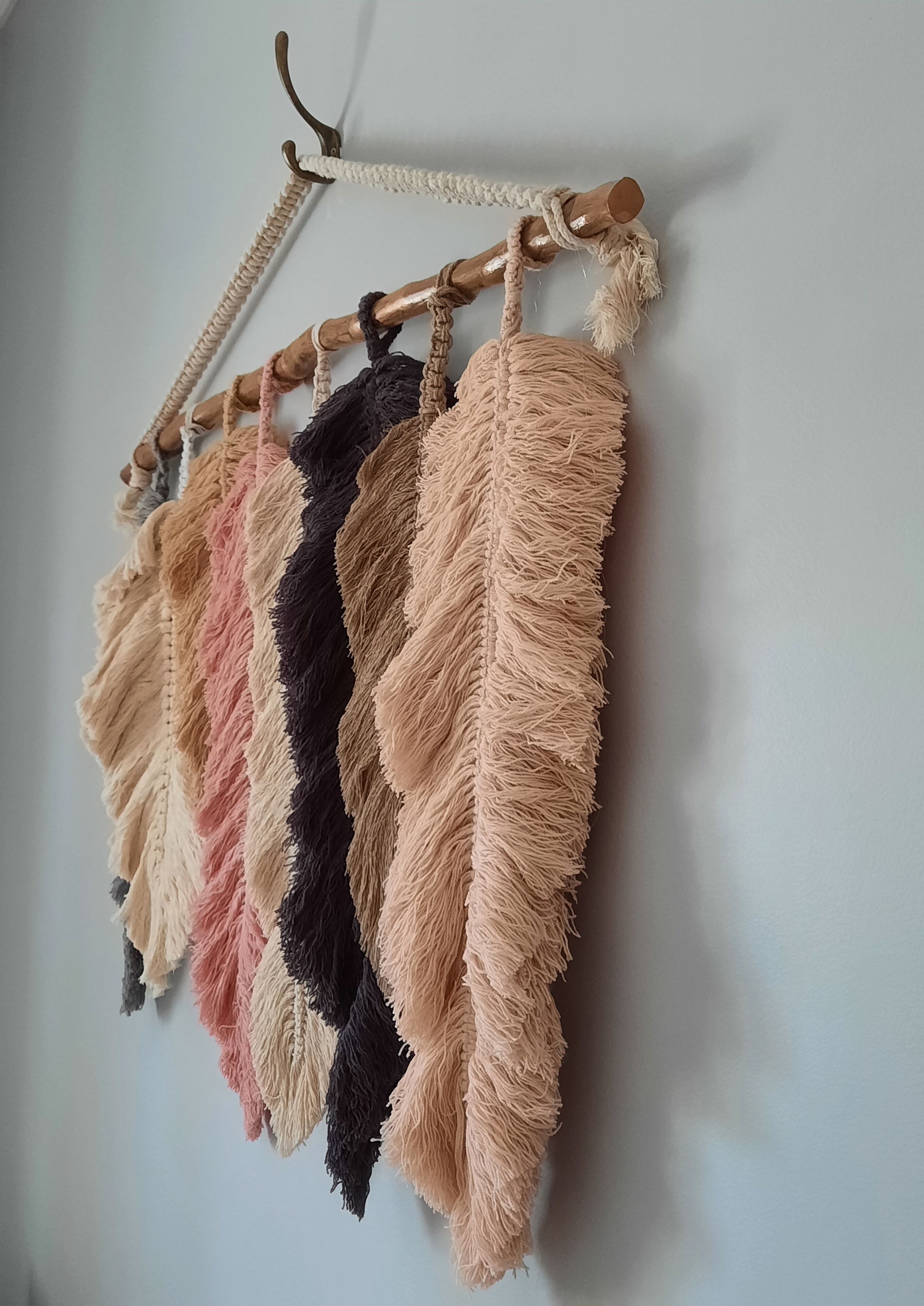 Un tapiz de macramé con flecos en varios colores.