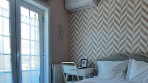 A hotel room with a bed, a desk, and an air conditioning unit. - Smiling Places (Vila do Conde)