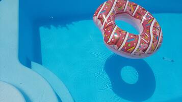 Una piscina con un flotador de rosquilla inflable.