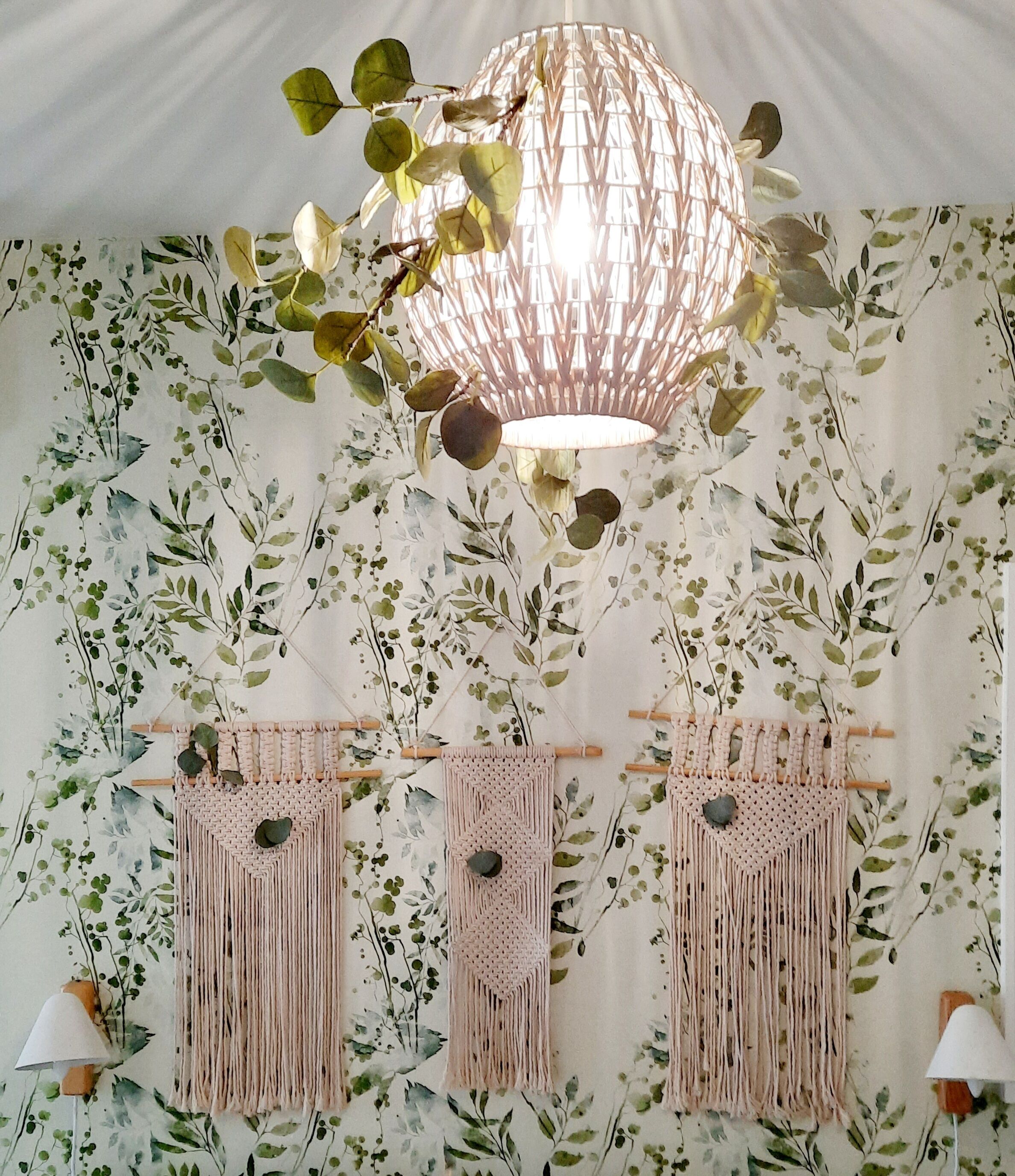 Una habitación con un tapiz de macramé, una lámpara de macramé y un tapiz de macramé con un adorno con forma de corazón.