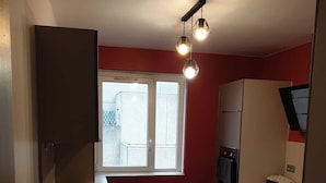 Et lille køkken med spiseplads, der inkluderer et vindue, en brødrister og et køleskab.