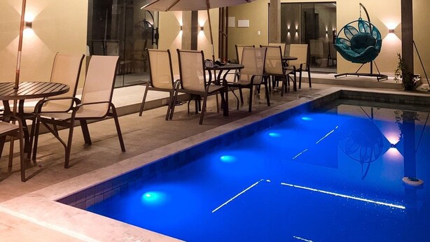 A modern outdoor pool area with multiple levels, lounge chairs, and umbrellas. - Pipa Day Flats (Tibau do Sul)