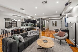 A modern living room with a grey sofa, a round coffee table, and a grey armchair.