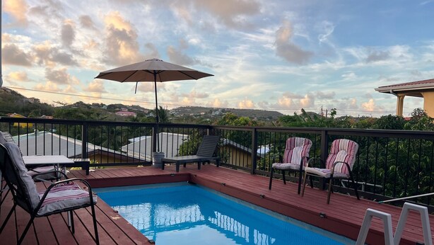 Una piscina con lettini e un ombrellone sulla terrazza.